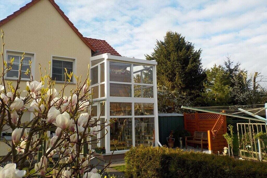 A house with a glass conservatory and a wooden deck.