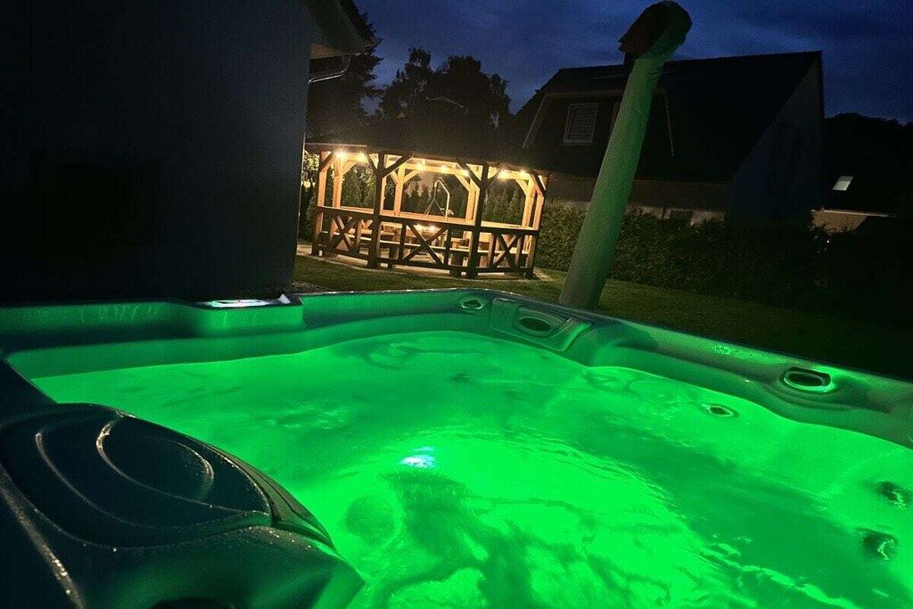 A hot tub with a wooden deck in the background.