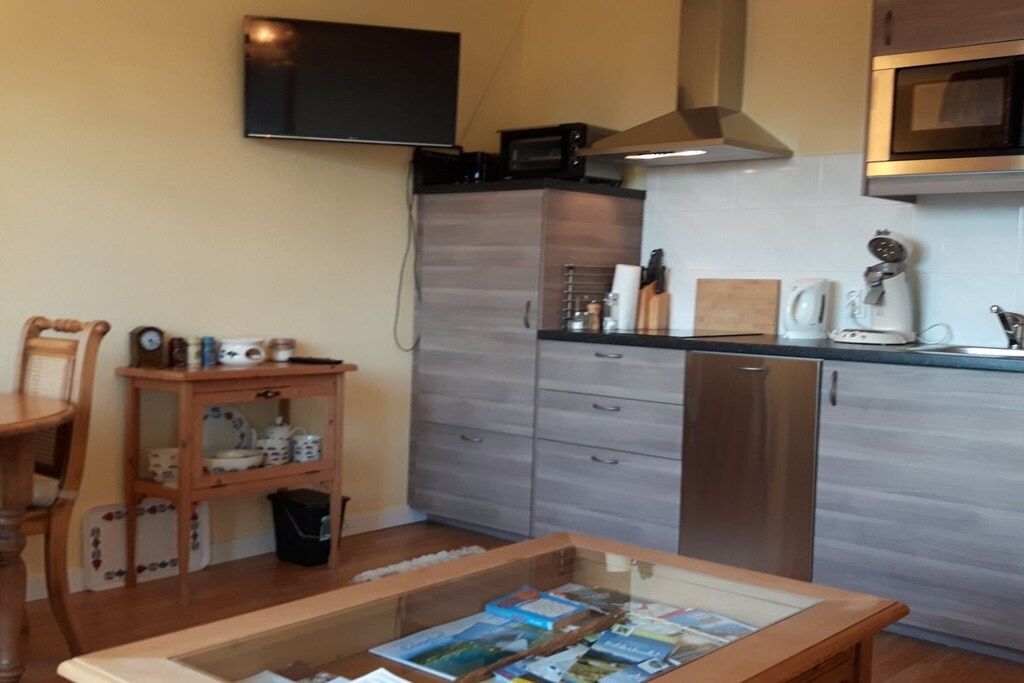A compact kitchen with a microwave, stove, and modern cabinetry.