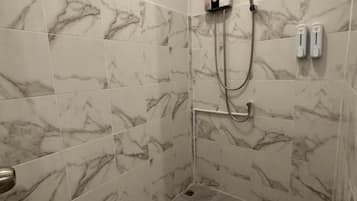 A shower with a handheld showerhead and a wall-mounted control panel.