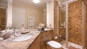 Een badkamer met een wastafel, toilet en douchecabine.