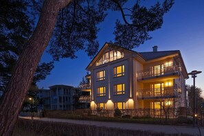 Ein mehrstöckiges Hotel mit Balkonen, großen Fenstern und einer gut beleuchteten Fassade.