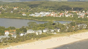Een kustplaats met een strand, huizen en een meer.