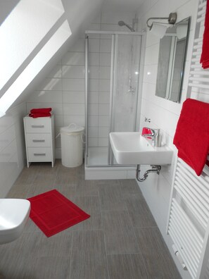 Ein modernes Badezimmer mit Dusche, Waschbecken und Toilette.