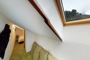 A room with a sloped ceiling, a skylight, a bed, and a small bedside table. - Holiday apartment with 3 bedrooms (Patergassen)