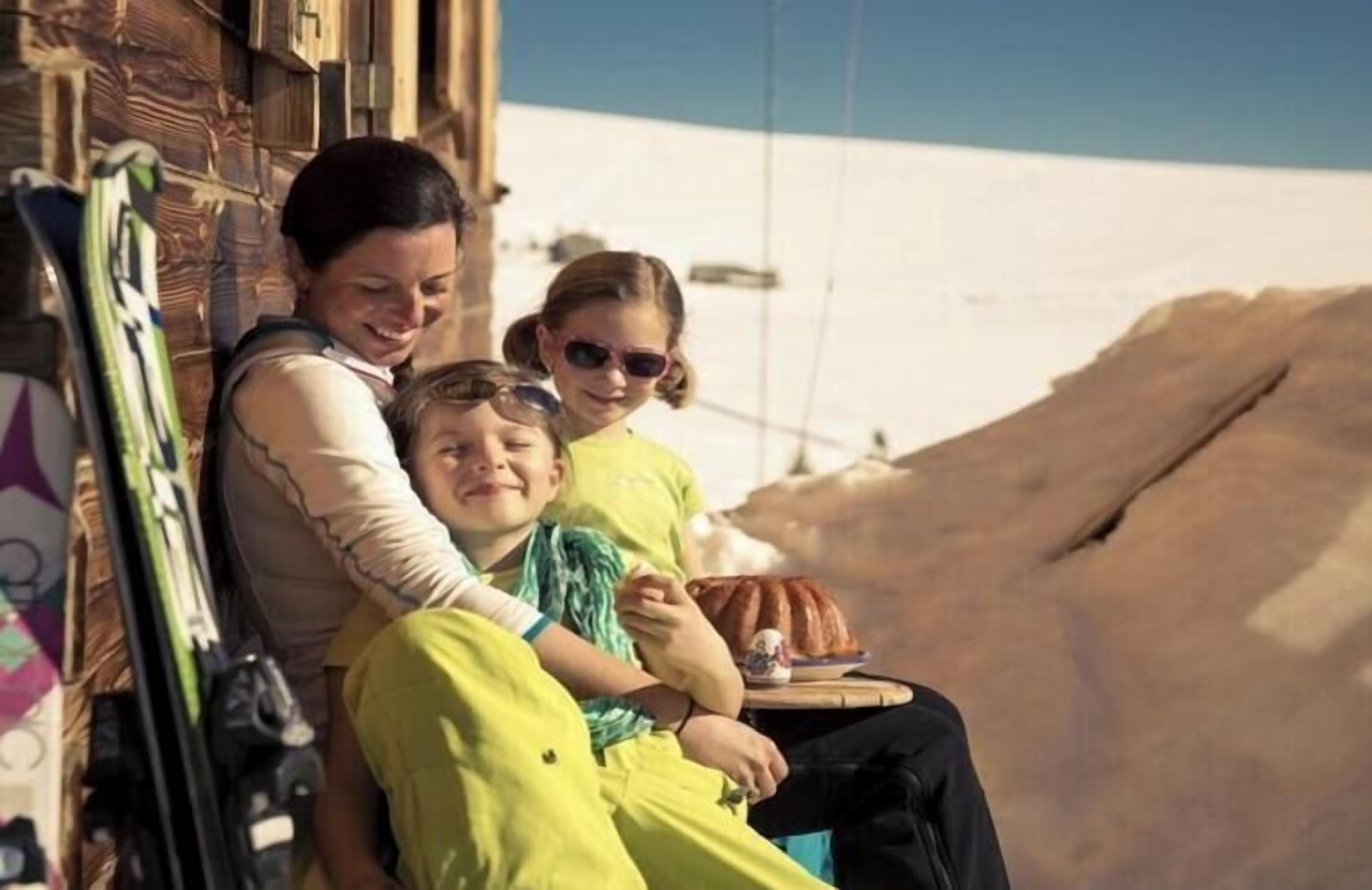 A family of four seated at a table with a view of a snowy landscape.