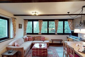 A cozy living room with a sofa, a small table, and a television. - Holiday apartment with 3 bedrooms (Patergassen)