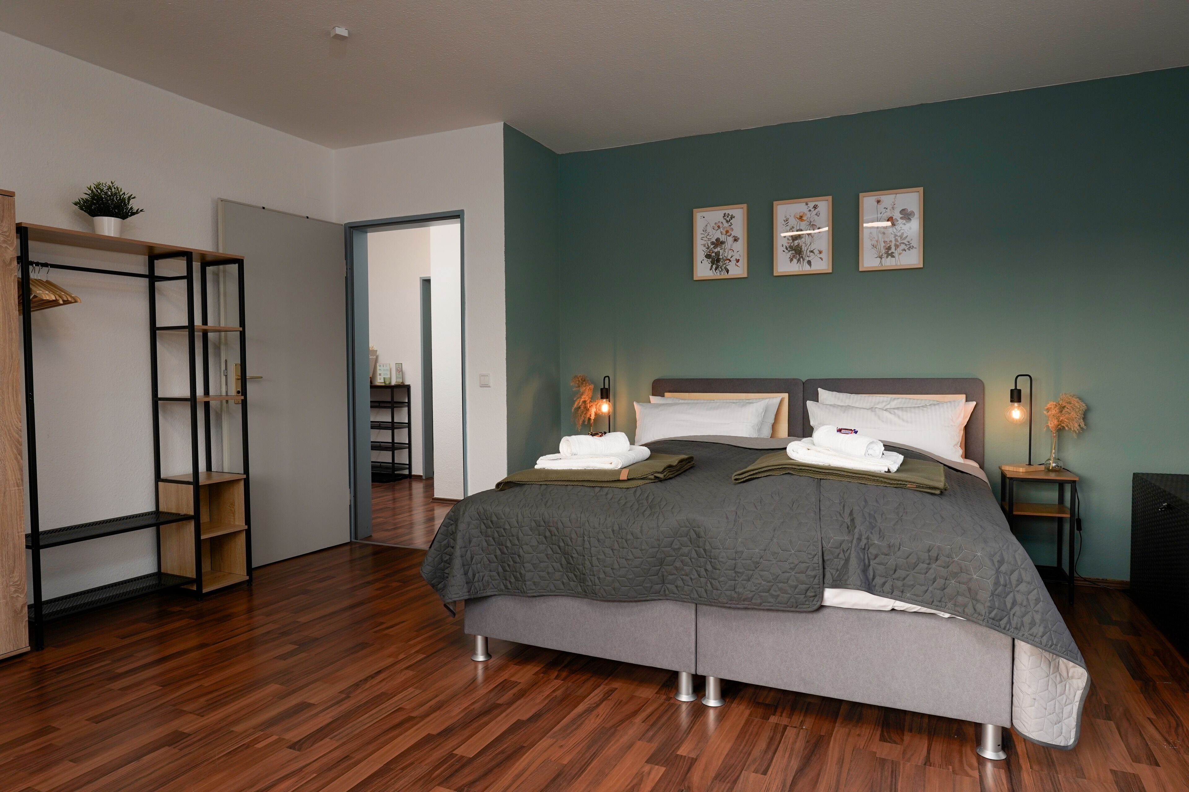 Ein modernes Schlafzimmer mit einem großen Bett, einem Kleiderschrank und einem Schreibtisch.