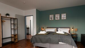 Een moderne slaapkamer met een groot bed, een kledingkast en een bureau.