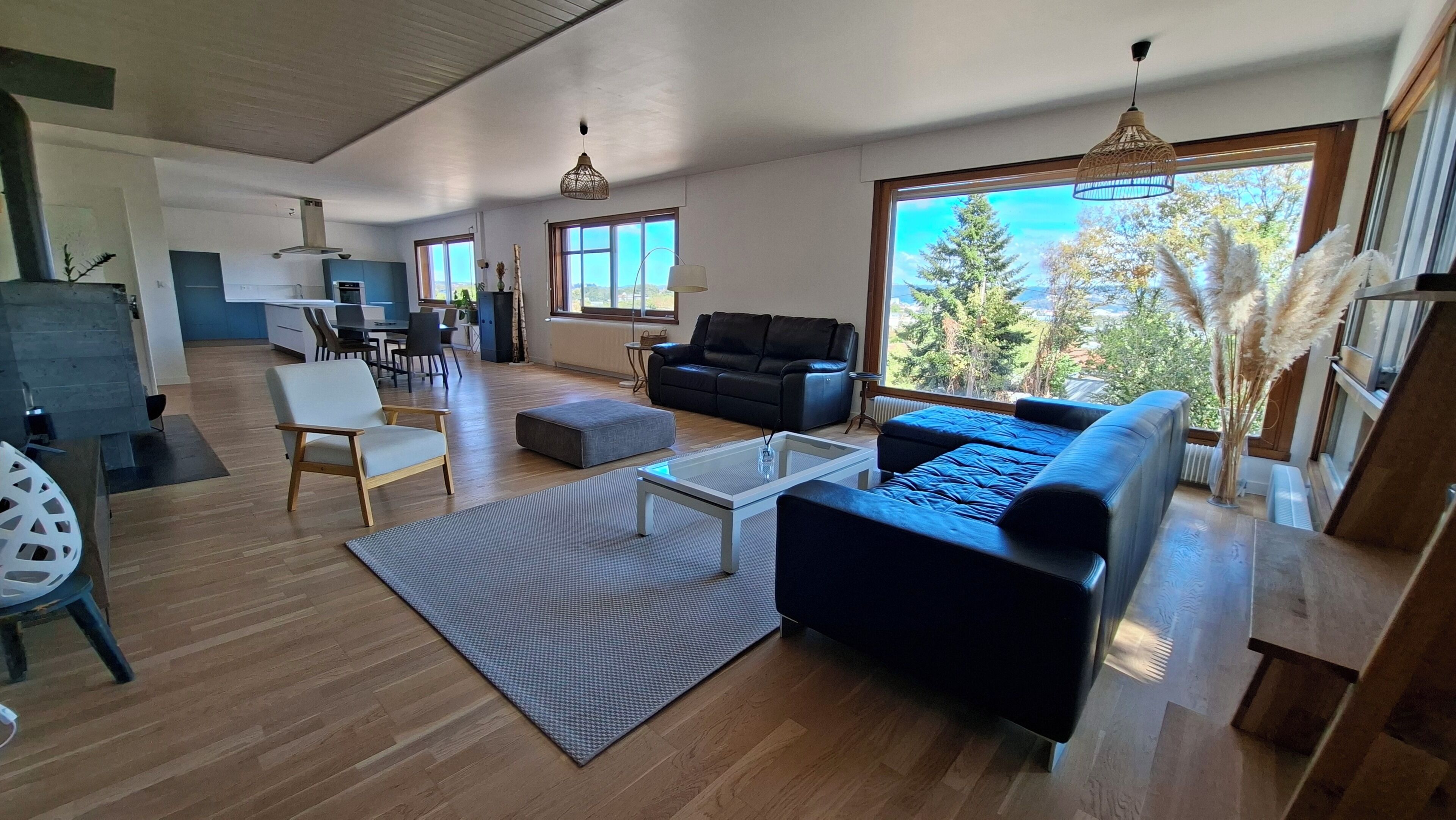 Un salon moderne avec un canapé, une table basse et une vue sur l’extérieur.