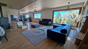A modern living room with a sofa, coffee table, and a view of the outdoors.