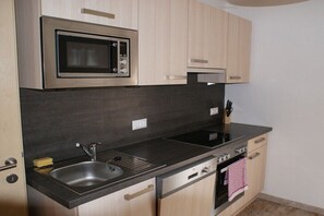 A modern kitchen with a built-in microwave, stainless steel sink, and a dishwasher. - "large holiday home" (Bodensdorf am Ossiachersee)