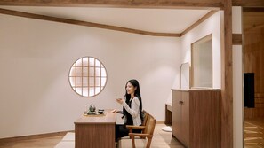A room with a round window, a wooden cabinet, and a table with a tea set. - Muonjae by Anook Suwon Heanggung (Suwon)