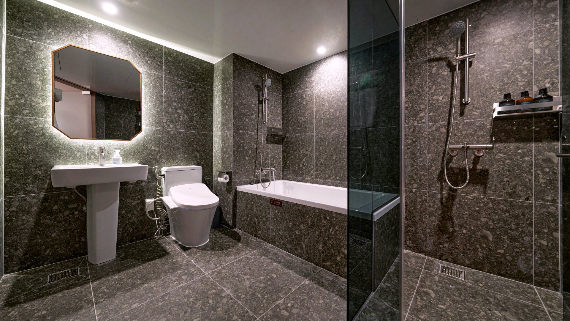A modern bathroom with a toilet, sink, and shower area.