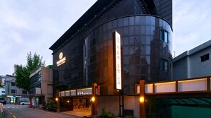 A modern hotel building with a curved facade, large windows, and a prominent sign for MuonJae Hotel & Spa. - Muonjae by Anook Suwon Heanggung (Suwon)