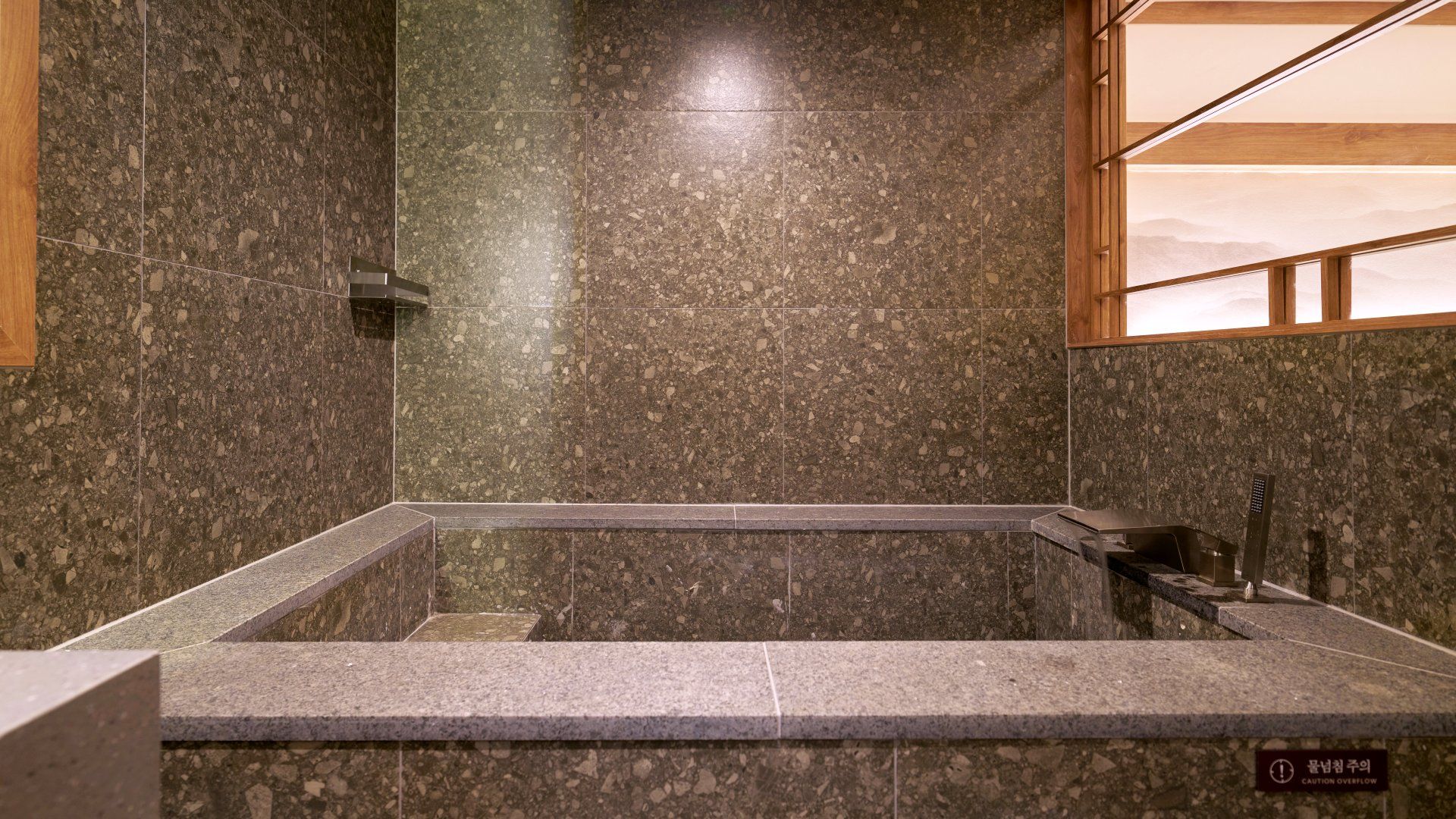 A bathroom with a rectangular shower area, a wooden-framed window, and a caution sign on the wall.