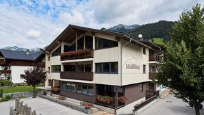 Un hotel de varios pisos con balcones, vista a la montaña y un cartel que dice 'APART-MARINEBERG'.