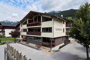 A multi-story hotel with balconies, a mountain view, and a sign indicating 'APART-MARINEBERG'. - Vrbo Property (Lermoos)