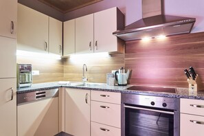 A modern kitchen with a built-in oven, a coffee machine, and a kettle. - Vrbo Property (Lermoos)