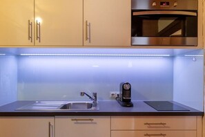 A modern kitchen with a built-in oven, a sink, and a coffee maker. - Top 7 for 2 people / Ground floor (Schröcken)