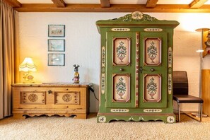 A room with a wooden cabinet, a lamp, and framed pictures on the wall. - Top 16 for 2-6 people / 2nd floor (Schröcken)