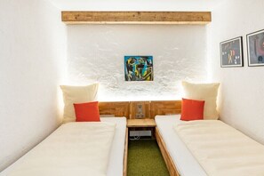 A small, cozy room with two single beds, a wooden headboard, and a wall-mounted artwork. - Top 17 for 2-4 people / 2nd floor (Schröcken)