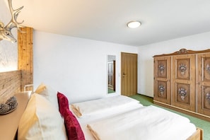 Ein Schlafzimmer mit zwei Betten, einem Holzschrank und einer Dekoration mit Hirschgeweih.