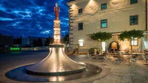 A courtyard with a central sculpture, outdoor seating, and a building in the background. - Vacation Rental/Apartment for 6 Guests, 62 m², in Freistadt (317570) (Freistadt)