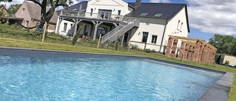 A swimming pool with a house in the background.