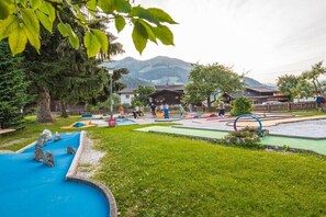 A playground with a blue slide and various play structures. - Holiday home in Rauris with swimming pool (Rauris)