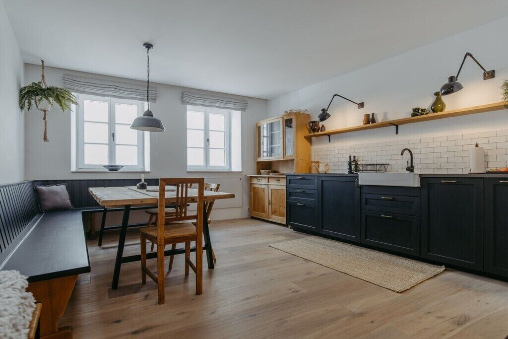 Eine moderne Küche mit Essbereich, ausgestattet mit einer Bank, einem Holztisch und Stühlen.