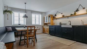 Eine moderne Küche mit Essbereich, ausgestattet mit einer Bank, einem Holztisch und Stühlen.