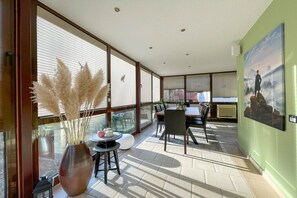 A sunlit room with large windows, a dining table, chairs, and a vase with pampas grass. - Holiday home with 1 bedroom (Rudolstadt \/ OT Eichfeld)