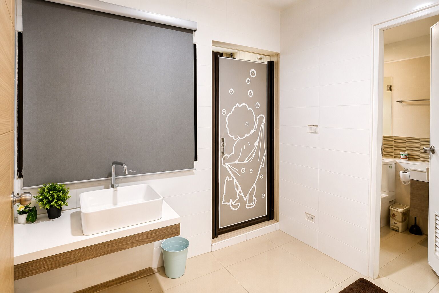 Un baño con un lavamanos blanco, un espejo, un perchero y una puerta con un diseño de personaje de dibujos animados.