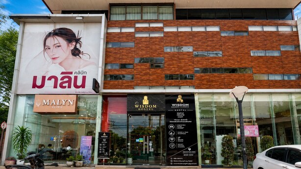 A modern building with a clinic, hostel, and a large advertisement. - Wisdom Muangthong Hostel (Pak Kret)
