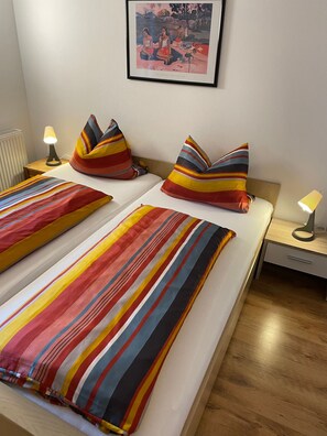 A hotel room with two beds, striped bedding, a framed picture on the wall, and bedside lamps. - Vrbo Property (Ehrwald)