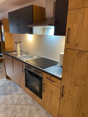 A kitchen with a built-in oven, a sink, and a stove. - Vrbo Property (Ehrwald)