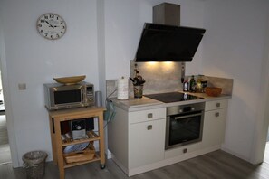A compact kitchen with a microwave, oven, and sink. - Holiday home with 2 bedrooms (Burg (Spreewald))