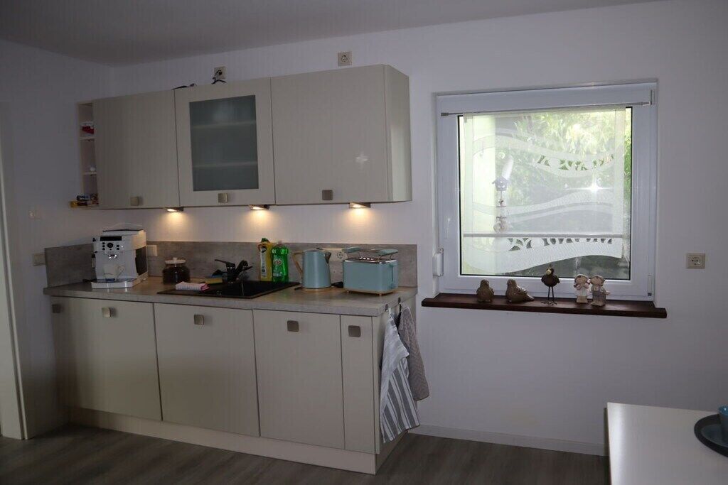 Een moderne keuken met ingebouwde kasten, een koffieapparaat en een raam met uitzicht op een brug.