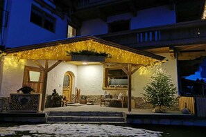 A building with a covered porch, a Christmas tree, and outdoor seating. - Holiday apartment with 3 bedrooms (Zell am Ziller)