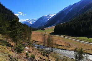 A mountainous landscape with a road, a river, and dense forests. - Self-catering hut Potzalm (Kleinsölk)