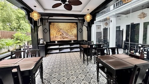 En restaurant med et traditionelt design, komplet med et mønstret gulv, sort og hvid indretning og et stort vægmaleri.
