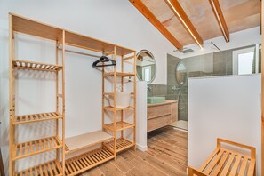 Ein modernes Badezimmer mit Holzböden, einem Spiegel und einer Duschkabine.