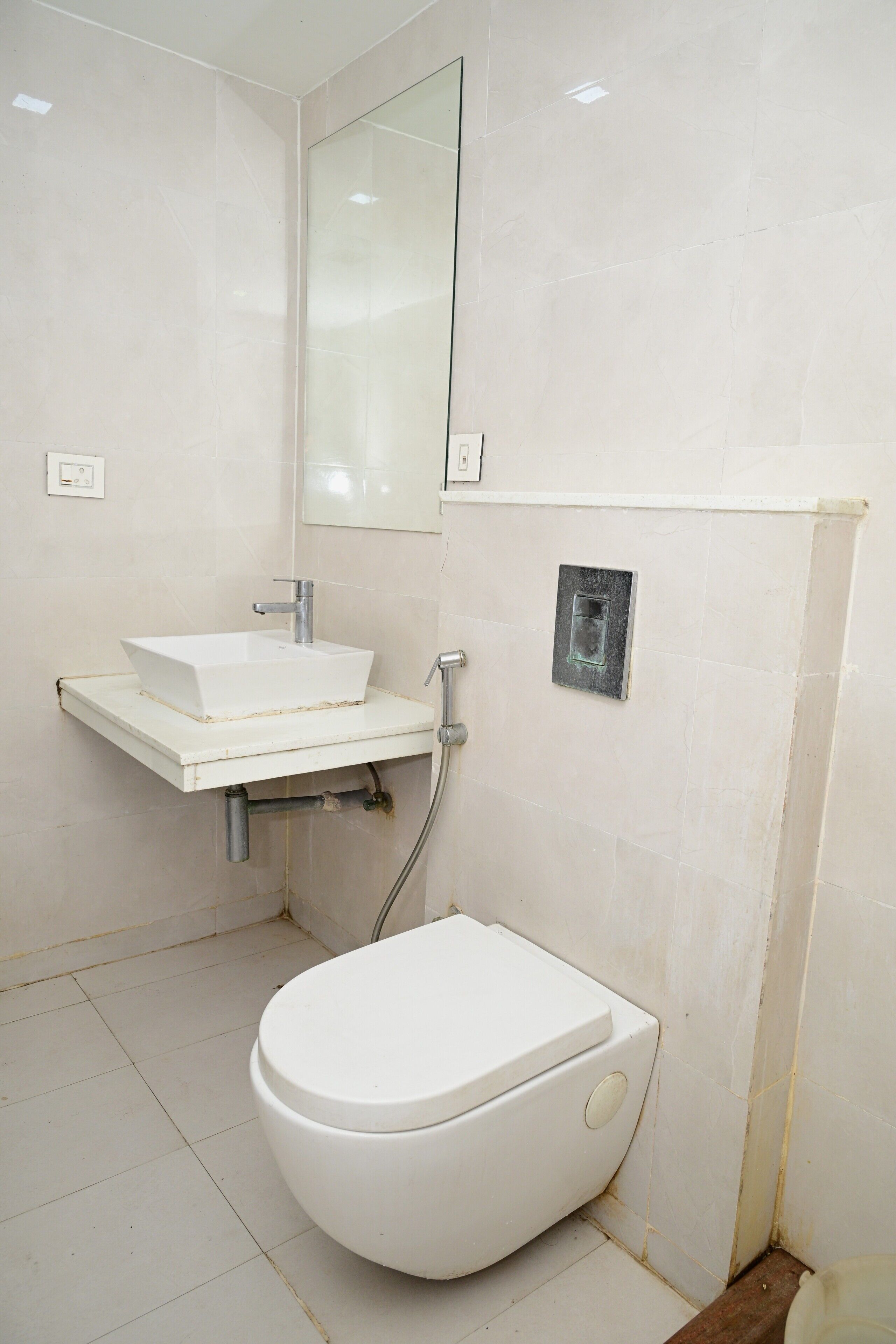 Un baño con inodoro, lavamanos y espejo.