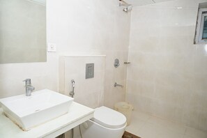Un baño con lavamanos, inodoro y ducha blancos.
