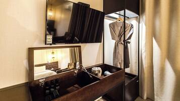 A hotel bathroom with a mirror, a robe hanging, and toiletries.