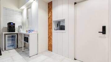A modern kitchen with a refrigerator, a coffee machine, and a microwave.