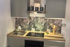 A kitchen with a modern design, featuring a stainless steel sink, a built-in oven, and a patterned backsplash. - Palazzo Jelo - Etna Apartments: Botanica in the heart of Catania, between the sea and Mount Etna (Catania)