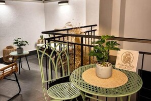 Eine grüne Metalltreppe mit einem Blumentopf auf der Zwischenebene.