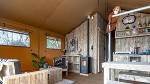 A cozy living room with a fireplace, wooden furniture, and a stuffed monkey on the wall. - Luxury Waterfront Safari Lodge (Almere)